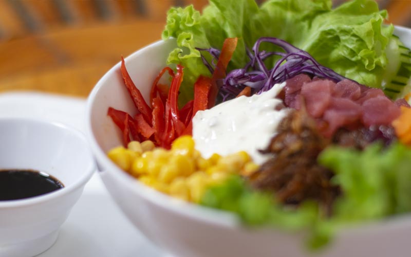 PalmBeach Tropical Restaurant | Tuna and Rice Poke | bowl of rice with raw tuna, corn, cucumbers, green salad, purple cabbage, fried onions, sesame seeds, mayonnaise and served with soy sauce on the sidebowl of rice with raw tuna, corn, cucumbers, green salad, purple cabbage, fried onions, sesame seeds, garlic mayonnaise and served with soy sauce on the side